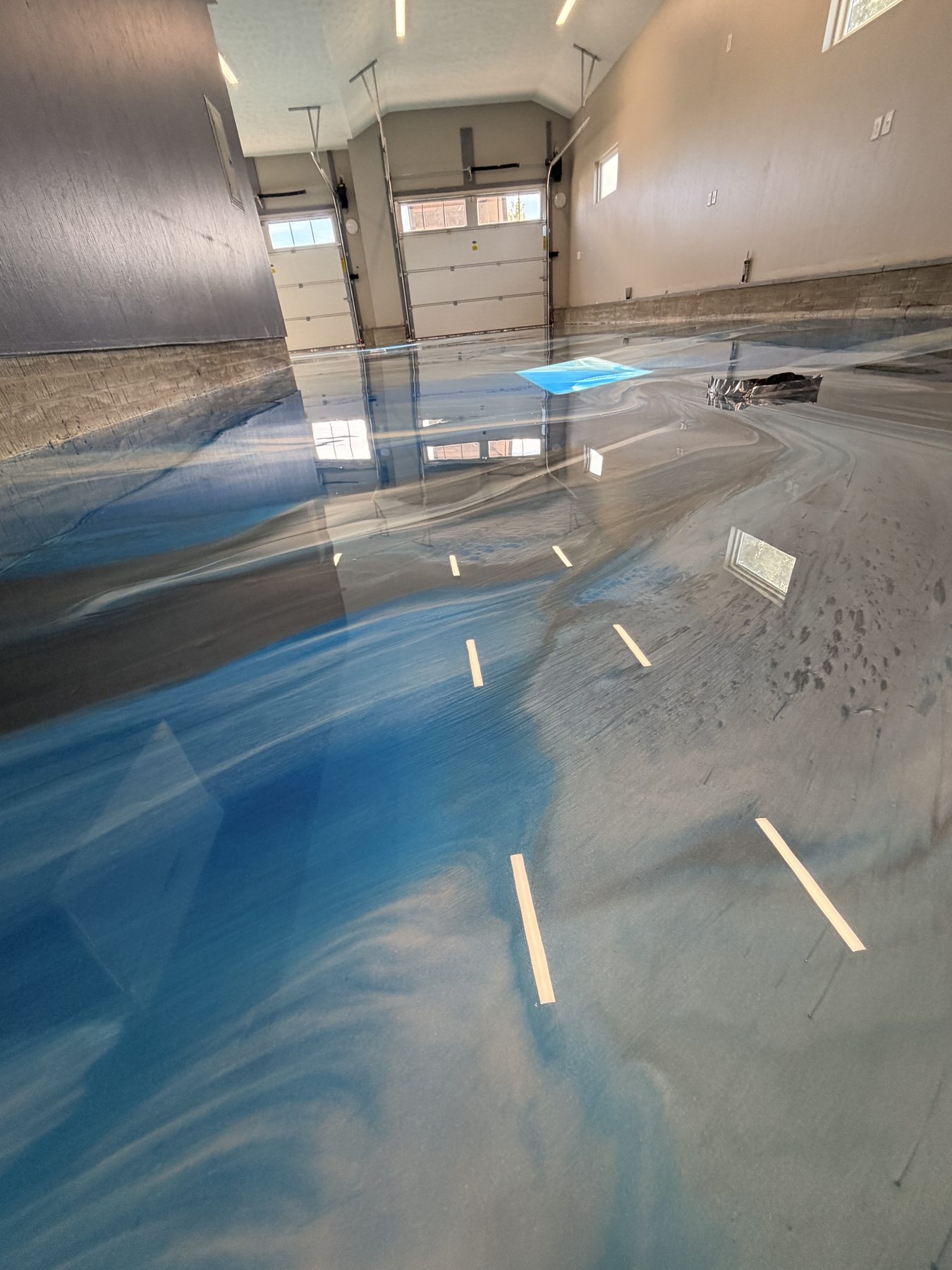 Blue and silver metallic epoxy garage floor with a high-gloss finish